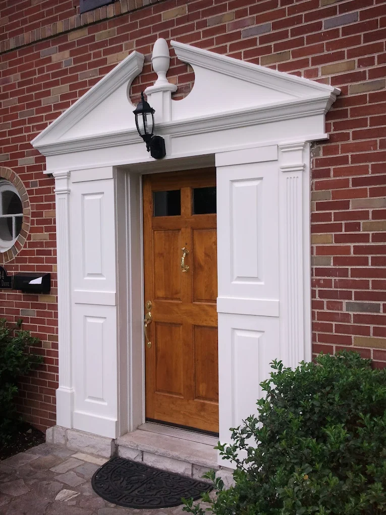 Wooden front door with custom white portico and trim
