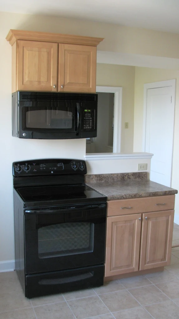 Kitchen with new maple cabinets, range, and microwave